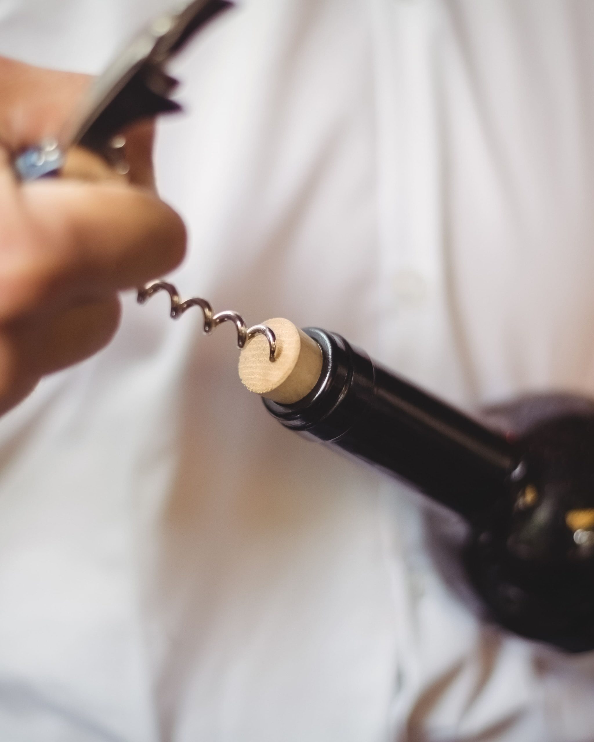 seccion-media-del-barman-abriendo-una-botella-de-vino2